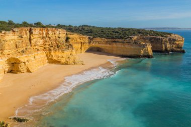 Praia da Marinha 'nın ünlü sahilinde dalgalar. Bu plaj Algarve 'nin ünlü turistik bölgesinin bir parçasıdır..