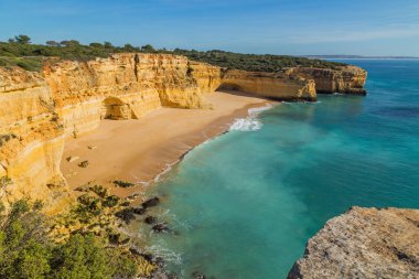 Praia da Marinha 'nın ünlü sahilinde dalgalar. Bu plaj Algarve 'nin ünlü turistik bölgesinin bir parçasıdır..