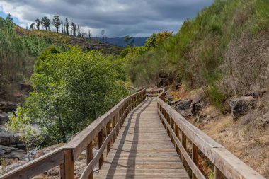 Arcos de Valdevez, Portekiz 'de Granit kayalar ve yemyeşil alanlarla çevrili Vez Nehri boyunca ahşap geçitler..