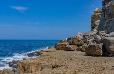 Engin Atlantik Okyanusu 'na karşı engebeli ve aşınmış kumtaşı platformları. Sintra, Portekiz