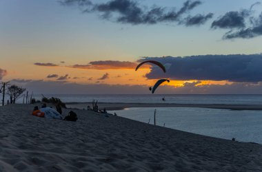 Pilat Kumulu, Fransa: Dune de Pilat 'ta paragliderler; ünlü Avrupa rüzgarlı noktası; günbatımında