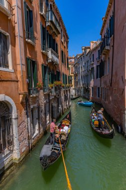 Venedik, İtalya: Dar kanal eski binalar ve gondolların süzüldüğü çiçekli pencerelerle kaplı