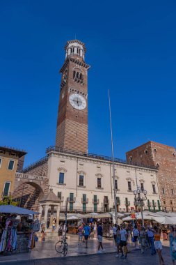 Verona, İtalya: Torre dei Lamberti (Lamberti Kulesi) pazar tezgahları ve tarihi mimarisi ile dolu canlı bir meydanın üzerinde yükseliyor