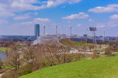 Münih, Almanya: Münih 'teki Olimpiyat manzarası, yemyeşil çimenler, ağaçlar ve Olimpiyat Stadyumu' nun ayırt edici mimarisi