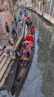 Venedik, İtalya: Kırmızı koltuklu Gondollar tarihi binalarla kaplı dar bir Venedik kanalı boyunca dinleniyor