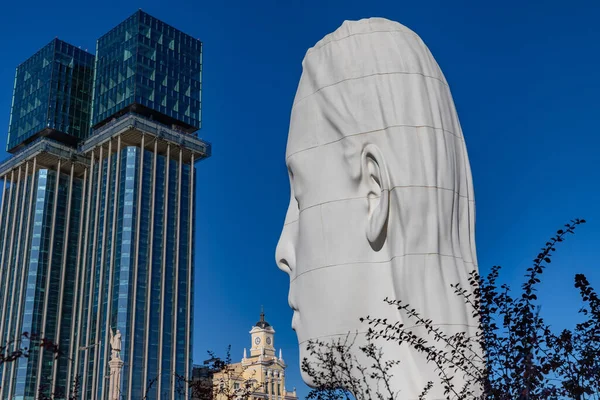 Madrid, Spain: Modern architecture and a giant head sculpture under clear blue skies in Madrids Plaza de Coln.