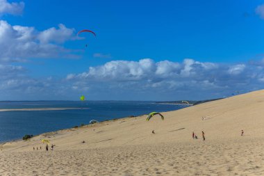 Pilat, Fransa 'nın Kumulu: Pilat, Arcachon Havzası, Nouvelle Aquitaine, Fransa' da insanlar yamaç paraşütü yapıyor.