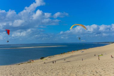 Pilat, Fransa 'nın Kumulu: Pilat, Arcachon Havzası, Nouvelle Aquitaine, Fransa' da insanlar yamaç paraşütü yapıyor.