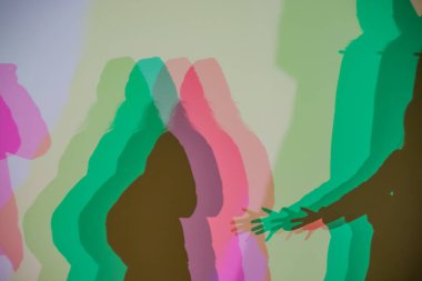 Renkli gölgeler, RGB aydınlatması boyunca duvara vurularak soyut ve sanatsal bir etkileşim yaratıyor insan siluetleri ve üst üste binen ışık.