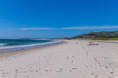 Coruna, Galiçya, İspanya: Galiçya 'da güneşli bir sahil, dinlenen ve güneşlenen insanlar.