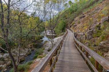 Arcos de Valdevez, Portekiz 'de Granit kayalar ve yemyeşil alanlarla çevrili Vez Nehri boyunca ahşap geçitler..