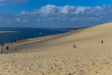Pilat, Fransa 'nın Kumulu: Pilat, Arcachon Havzası, Nouvelle Aquitaine, Fransa' da insanlar yamaç paraşütü yapıyor.