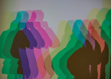 Renkli gölgeler, RGB aydınlatması boyunca duvara vurularak soyut ve sanatsal bir etkileşim yaratıyor insan siluetleri ve üst üste binen ışık.