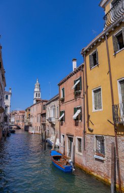 Venedik, İtalya: Renkli binalar ve demirlemiş teknelerle dolu sessiz bir kanal