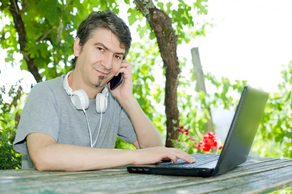 Uomo all'aperto che lavora con un computer portatile — Foto Stock