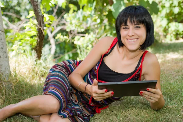 Femme occasionnelle travaillant avec une tablette pc, en plein air — Photo