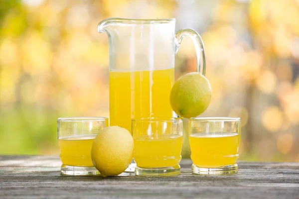 Zitronensaft auf Holztisch, Herbstset, draußen — Stockfoto
