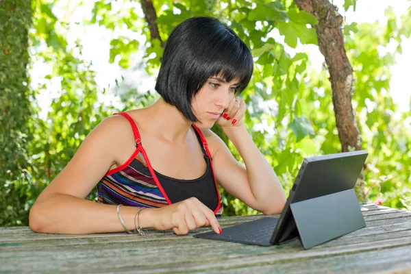 Mujer casual que trabaja con una tableta PC, al aire libre — Foto de Stock