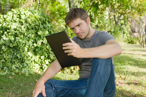 Przypadkowy mężczyzna pracujący z komputerem typu tablet, odkryty — Zdjęcie stockowe