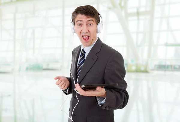 Empresário com tablet pc e fones de ouvido, no escritório — Fotografia de Stock