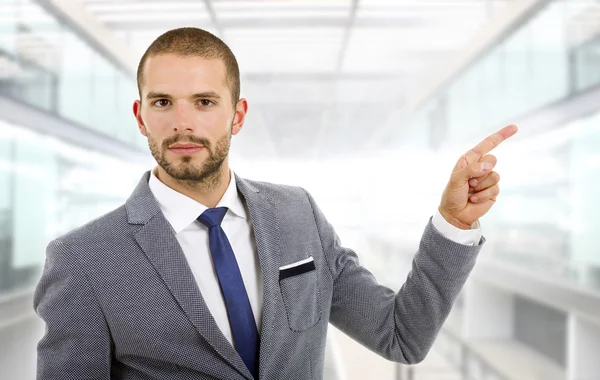 Businessman in a suit pointing with his finger at the office — Stock Photo, Image