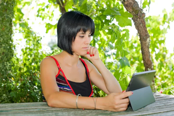 Casual kvinna som arbetar med en TabletPC, utomhus — Stockfoto