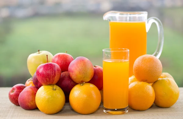 Bardak portakal suyu ve meyve ahşap tablo açık bir sürü — Stok fotoğraf