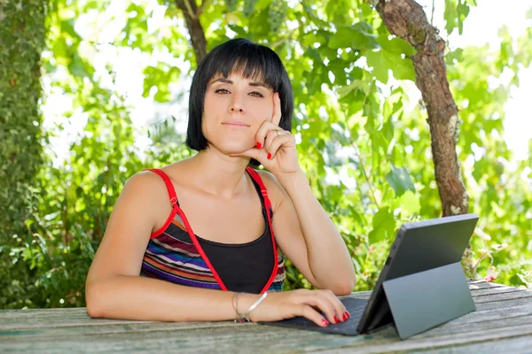 Casual kvinna som arbetar med en TabletPC, utomhus — Stockfoto