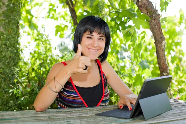 Casual kvinna som arbetar med en TabletPC, utomhus — Stockfoto