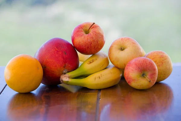 Olika frukter på bordet i trädgården — Stockfoto