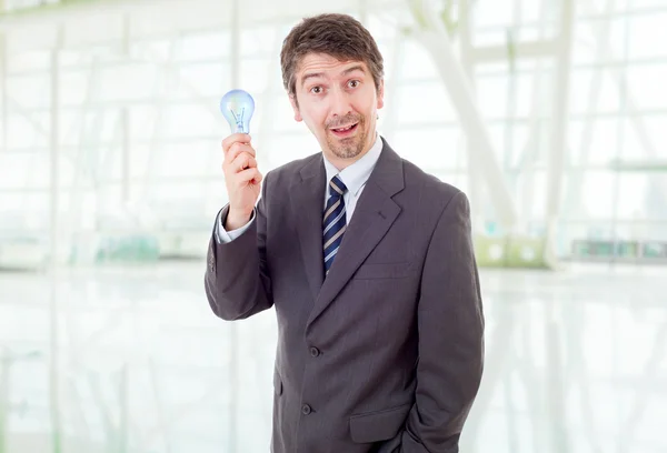 Silly business man with a lamp at the office — Stock Photo, Image