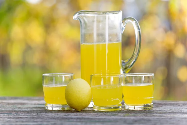 Suco de limão em uma mesa de madeira, jogo de outono, ao ar livre — Fotografia de Stock