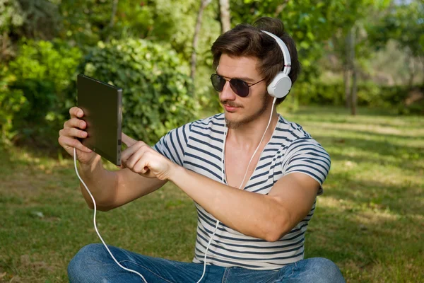 Przypadkowy mężczyzna trzymając tabletkę z słuchawki, odkryty — Zdjęcie stockowe