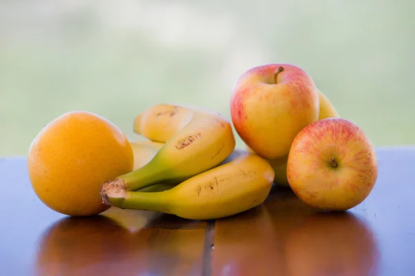 Różne owoce na stole w ogrodzie — Zdjęcie stockowe