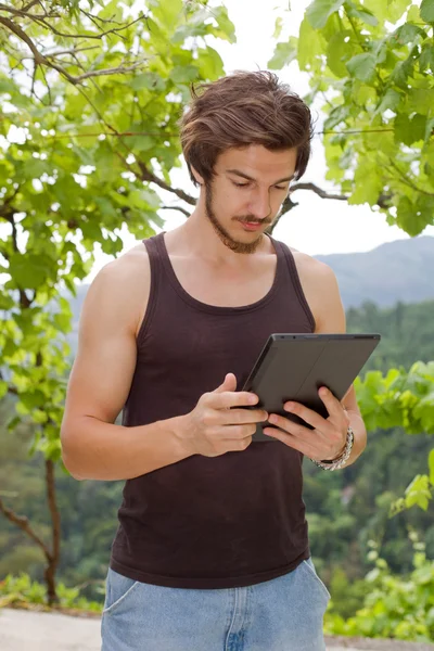Casual man die werkt met een tablet pc, buiten — Stockfoto