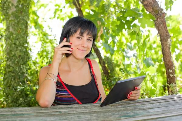 Femme occasionnelle travaillant avec une tablette pc, en plein air — Photo