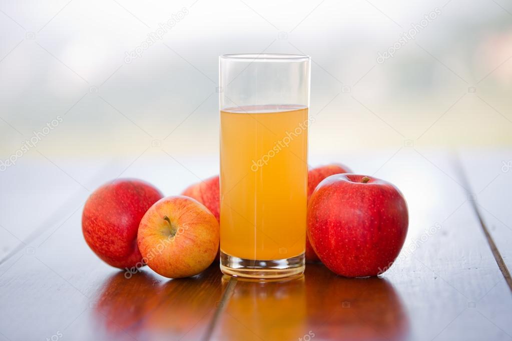 apples and juice on a wooden table, outdoor