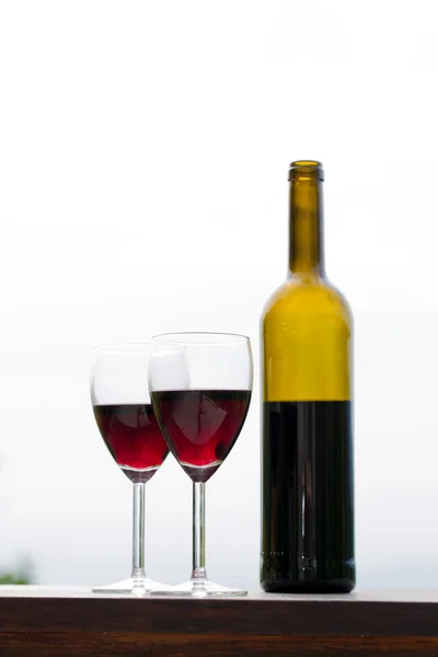 Czerwone wino w kieliszkach z butelki, odkryty — Zdjęcie stockowe