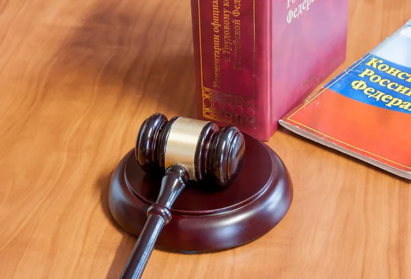 The judicial hammer and codes of laws lay on a table