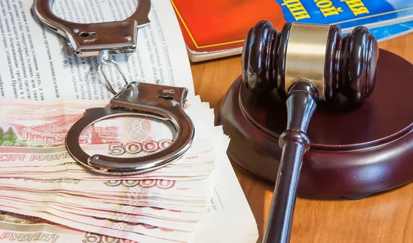 Martillo judicial, códigos de leyes, esposas y dinero — Foto de Stock