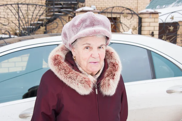 Arabanın yakınında kışın neşeli yaşlı kadın — Stok fotoğraf