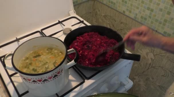 Женщина смешивает в сковороде овощи — стоковое видео