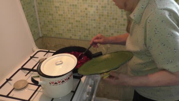 A mulher mistura em umas verduras de panela de ato de fritar — Vídeo de Stock