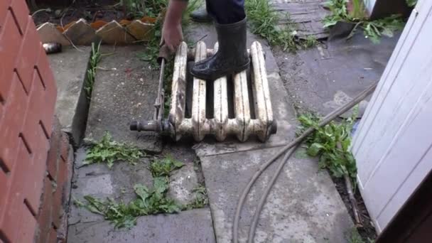 Homem girar tubo deslizando a chave no antigo radiador de ferro fundido — Vídeo de Stock