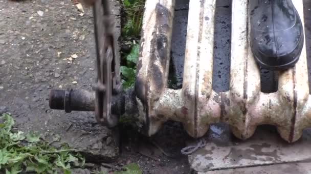 男人自旋管滑动中旧的铸铁散热器的关键 — 图库视频影像