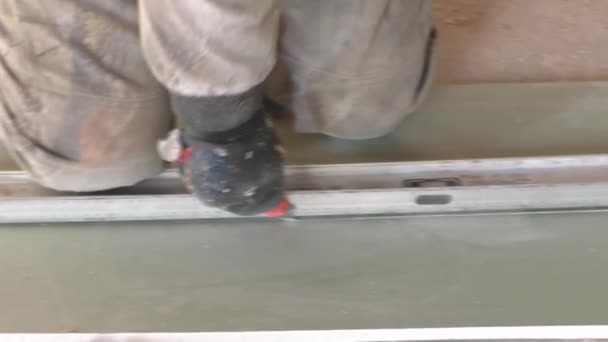 A worker cuts a plaster sheet knife — Stock Video