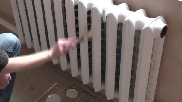 Женщина рисует радиаторы. — стоковое видео