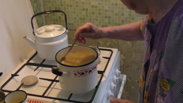 Mujer prepara sopa en una olla de gas — Vídeos de Stock