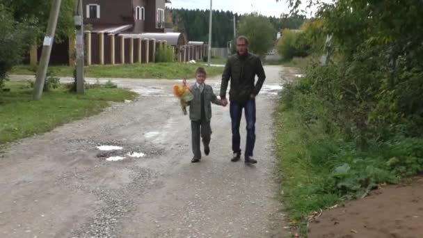 El chico con su padre va por el camino — Vídeos de Stock