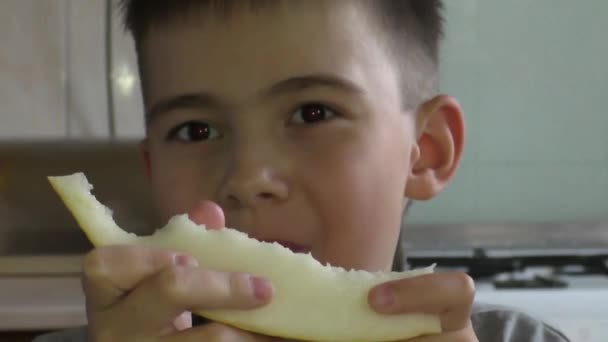 Мальчик ест дыню. — стоковое видео